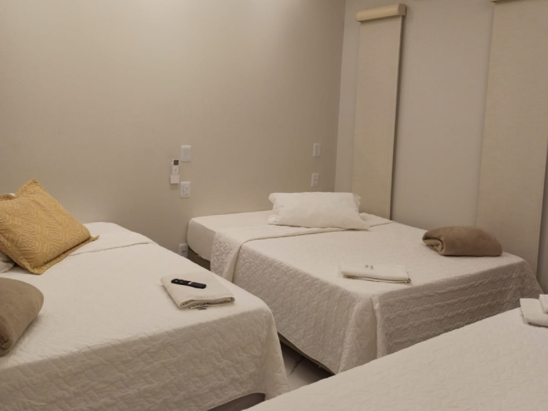 Quarto com uma cama de casal e duas de solteiro
